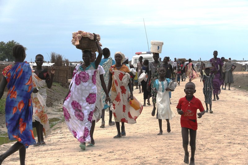 A group of displaced people from South Sudan walking on the road.