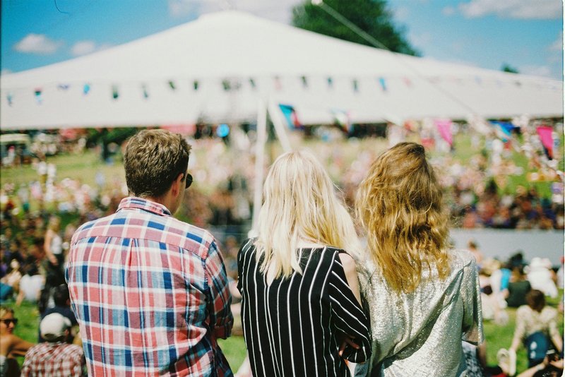 3 people sat in front of a marquee