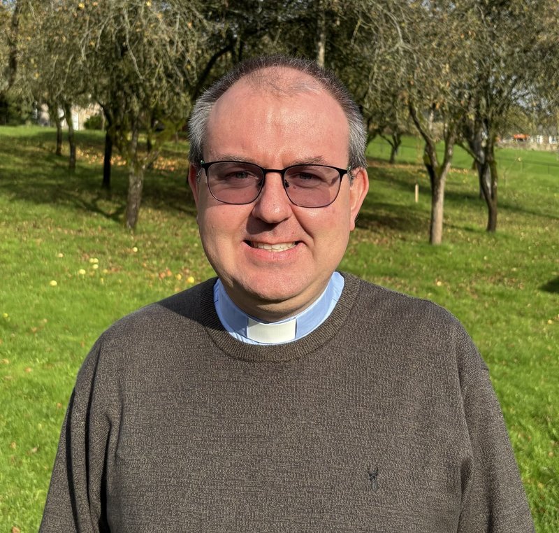Headshot of David Goodall in jumper and dog collar