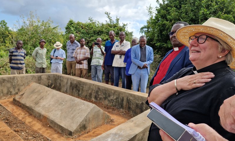 woman looks at modest missionary grave