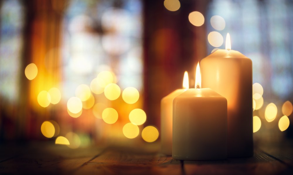 Candles burning in a church background