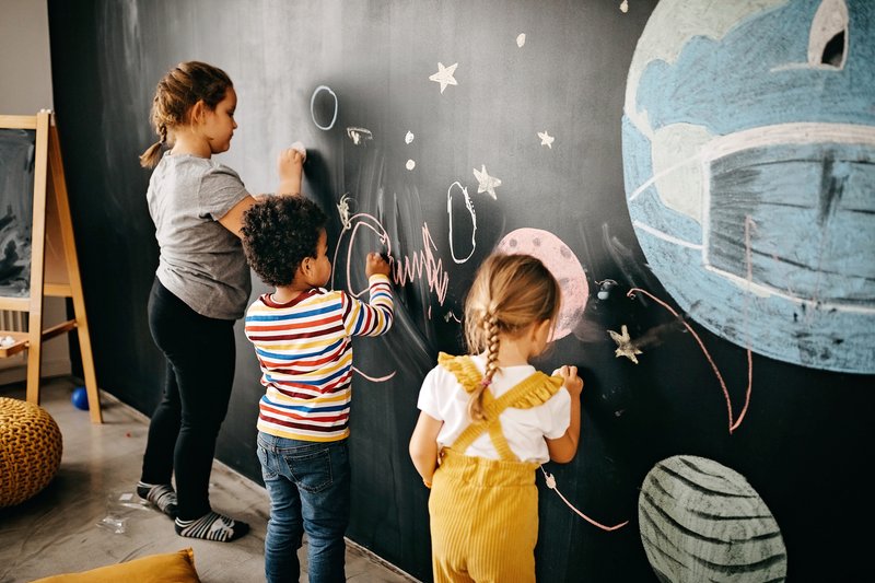 Children drawing on chalk board