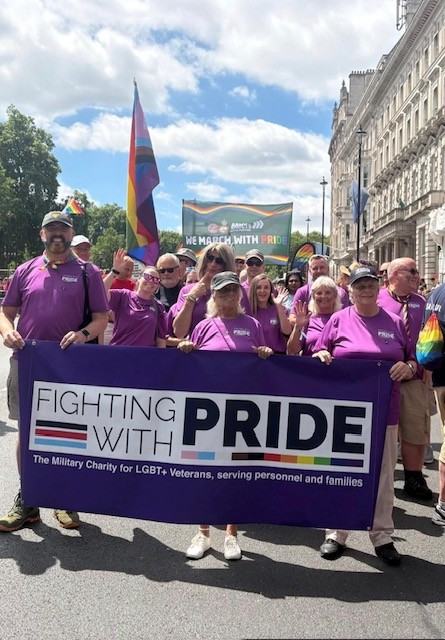 A group of people behind a purple pride banner