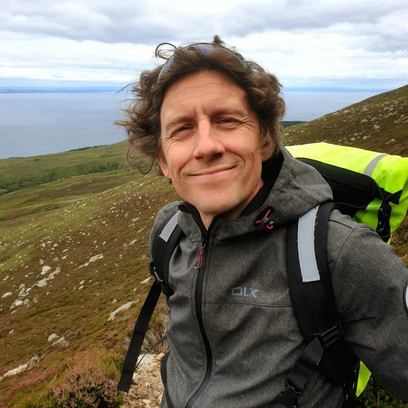 Head picture of the Revd Matt Finch, outdoors, standing halfway up a mountain.