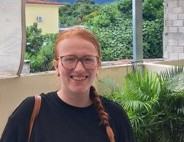 Gracie Silk standing in front of tropical trees