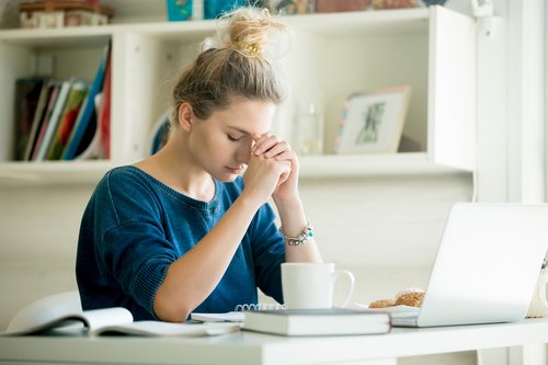 Praying at desk with laptop GettyImages-612736692