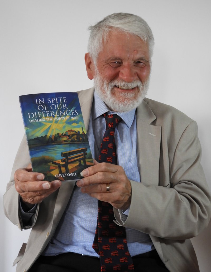 Image of Clive holding a copy of his book