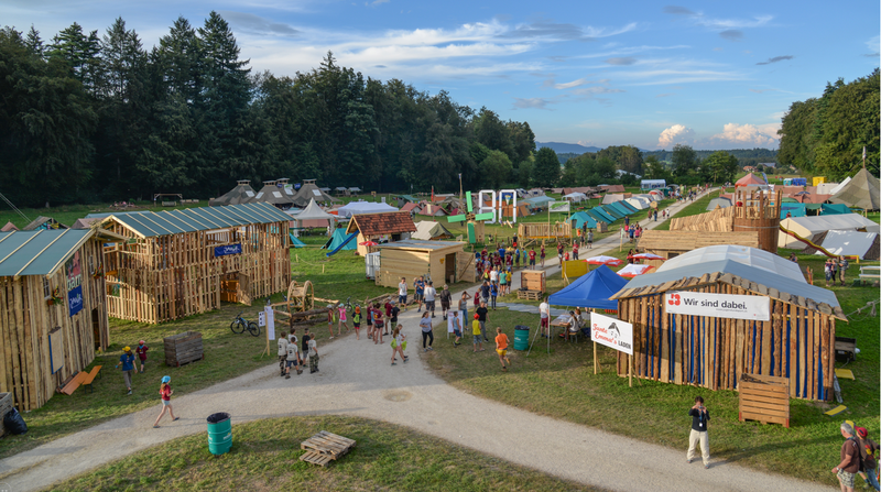tents across a field with young people walking between them