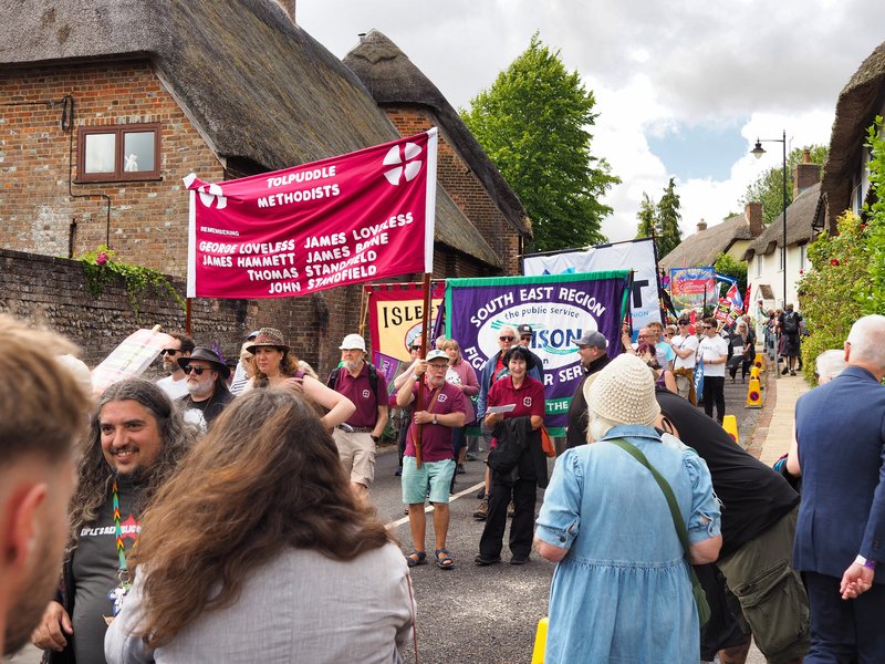 A wide shot of the Tolpuddle Festival procession showing the Tolpuddle Methodist banner