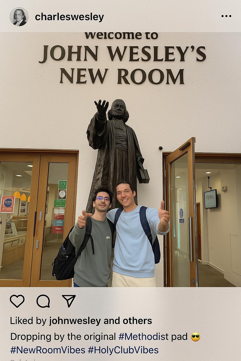 Two young men stand beneath a statue of John Wesley