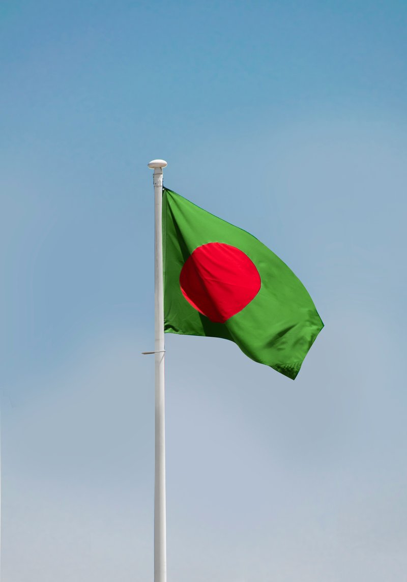 flag flapping in the wind, dark green with red circle in the middle