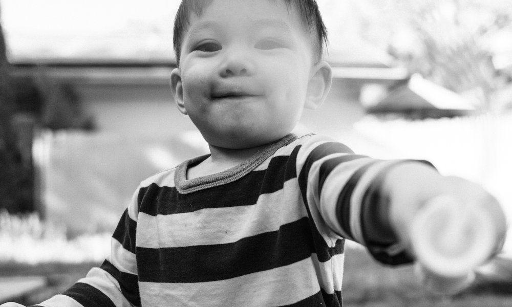 A toddler in a striped top excitedly playing with bubbles