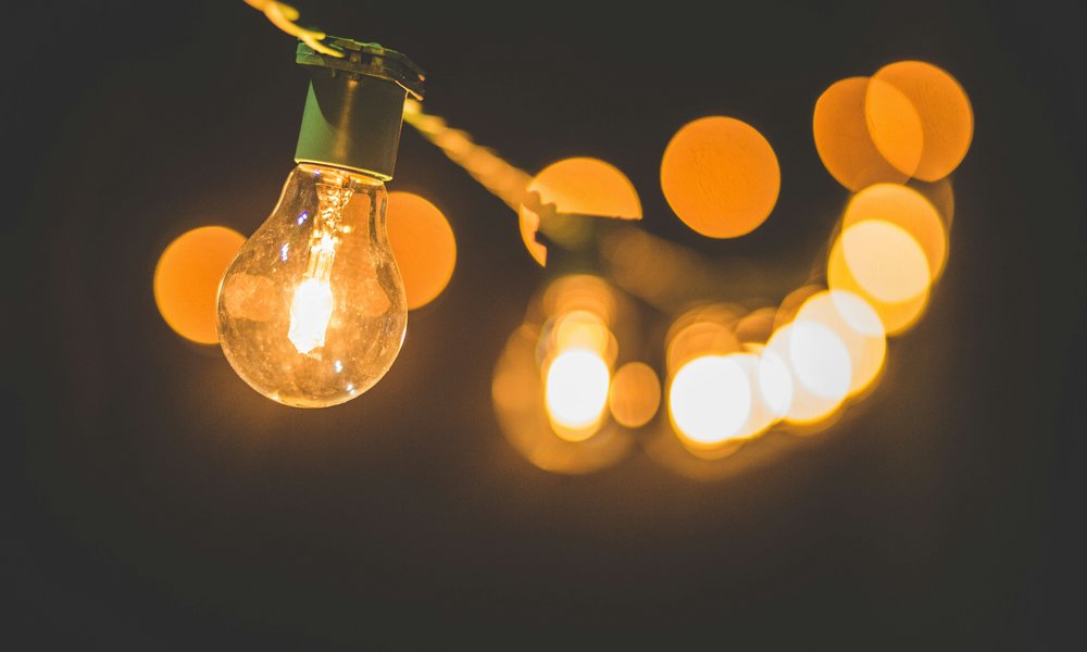 Lit lightbulbs on a rope against a dark blurred background