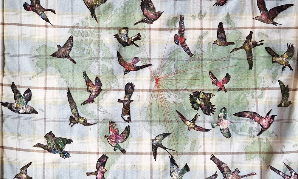 Wall hanging showing birds migrating across a world map