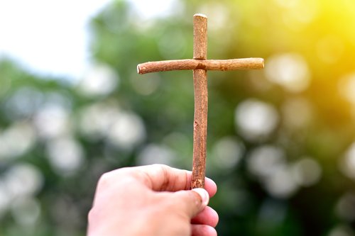 resurrection-hand-holding-small-wooden-cross-gettyimages-1366852948