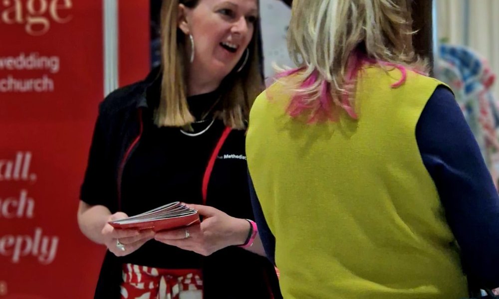 A female volunteer chats with a woman at the wedding show